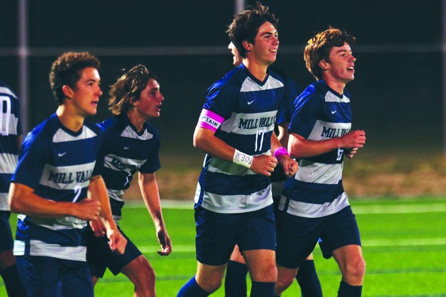 Wearing his pink captains band on the soccer field, Senior Ryan Wingard leads his team to midfield to assume his position as right wing on Oct. 28. 