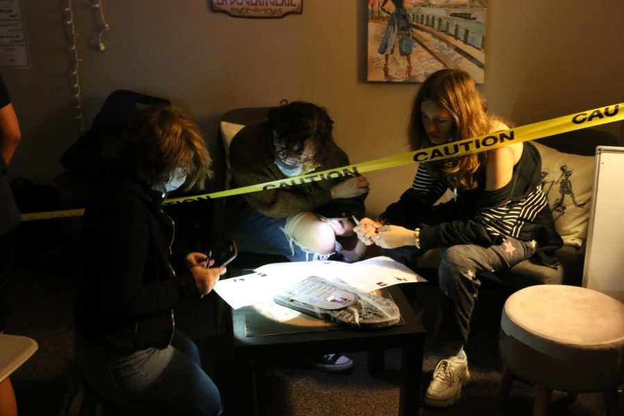 Sitting around a table, freshman Ava Bittner and her friends figure out the scavenger hunt.