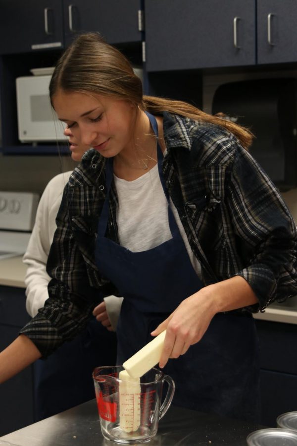 Preparing to make green bean casserole, junior Madison McClure adds butter to a measuring glass. 