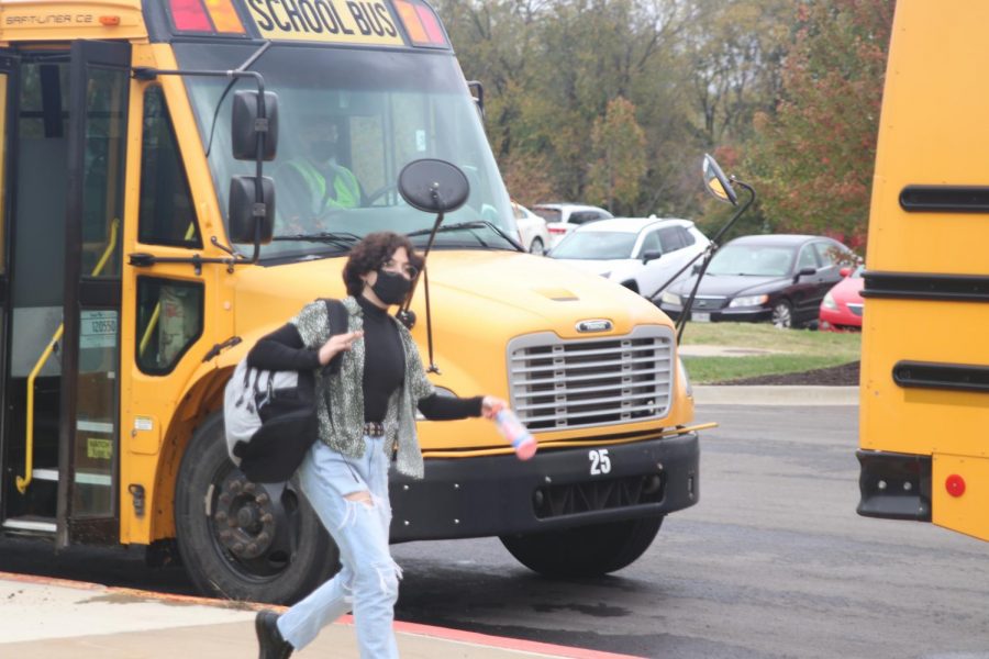 After school Friday, Oct. 29, junior Josie Foltz walks on the sidewalk, making her way towards the bus. 