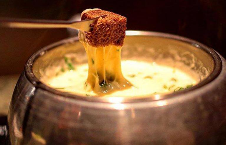 Bread is dipped into a type of cheese fondue. 
