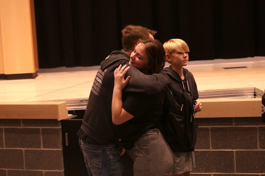 Sophomore Reagan Raether embraces Randy Davis after the assembly.