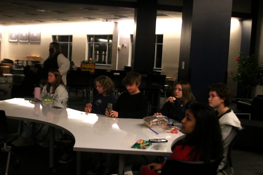 The members of Women Empowerment watch a movie with a group of their friends while eating snacks.
