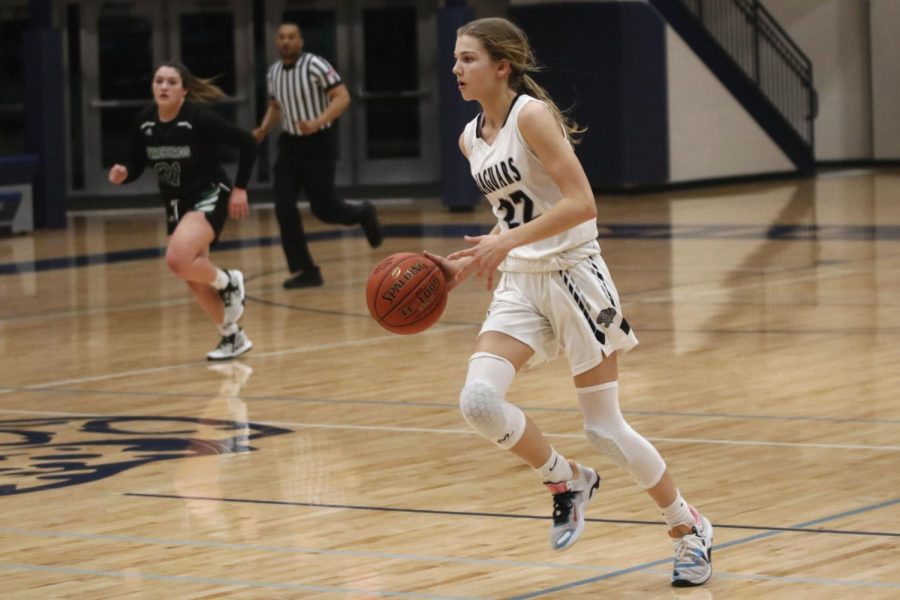 Dribbling the ball, freshman Averie Landon looks to see who is open. 