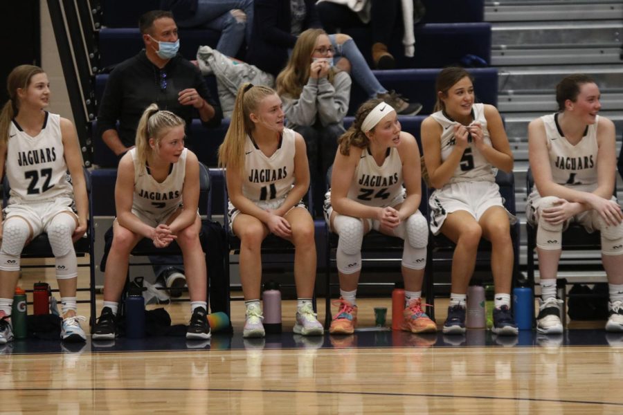 Focused on the game, sophomore Keira Franken, junior Sophie Pringle and seniors Emree Zars, Mackinley Fields and Maddie Vosburg watch their teammates. 