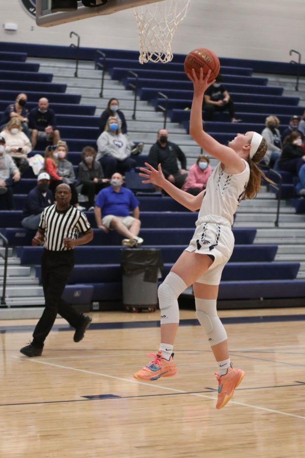 Jumping off the ground, senior Emree Zars shoots a layup. 