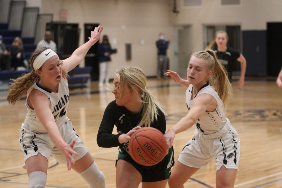 Arms stretched out, senior Emree Zars and junior Sophie Pringle guard a Free State player. The girls defeated Lawrence Free State at home Tuesday, Jan. 18 with a final score of 56-16. 