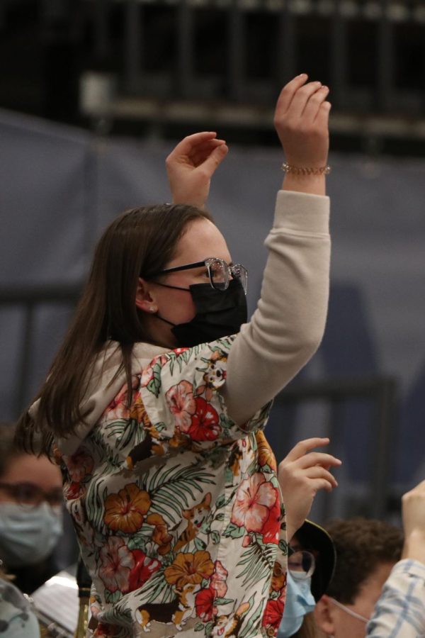 Senior Katelyn Kurovski lifts her arms up in the air and watches one of the girls shoot a free throw. 