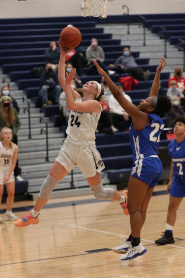 Jumping off the ground, senior Emree Zars shoots a layup.