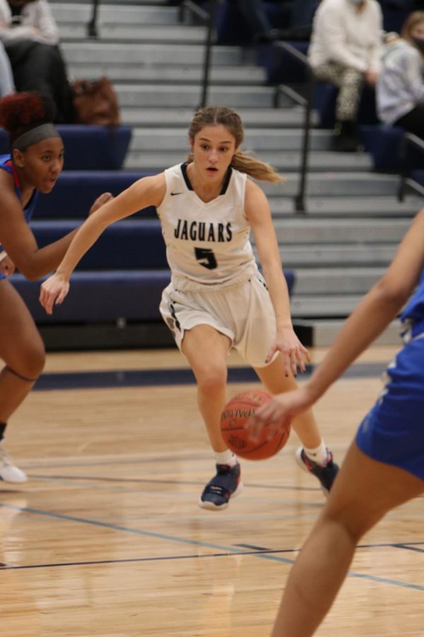 Driving down the court, senior Mackinley Fields dribbles the ball.