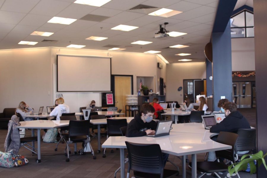 Sitting at new tables in the media center, students complete assignments on their laptops Thursday, Jan. 20.