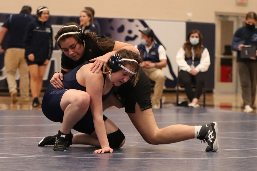 Trying to escape the starting position on the ground, senior Shaye Nielsen pushes up from the ground with her opponent on her back.
