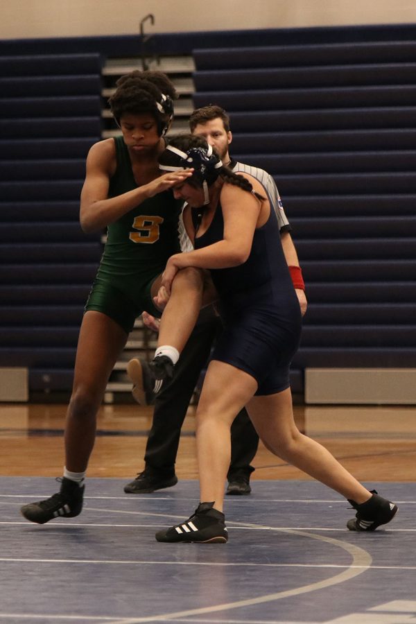 With her hands wrapped around her opponent’s thigh, senior Shaye Nielsen rushes back inside the circle to avoid losing points to her opponent.