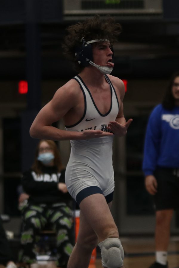 Celebrating his big win, sophomore Maddox Casella looks towards the crowd while pointing at the Mill Valley logo on his singlet.
