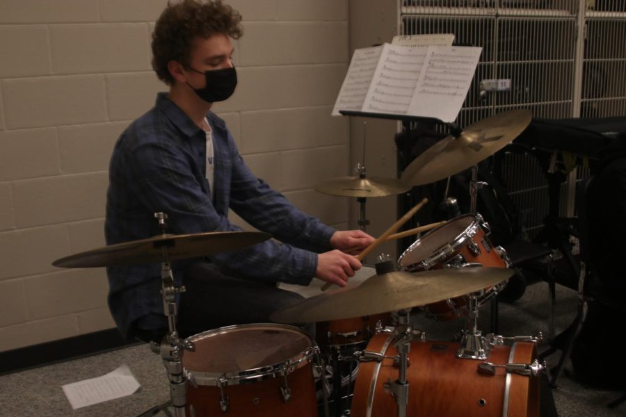 Holding the drumsticks, junior Finn Campbell focuses on playing the drums. 