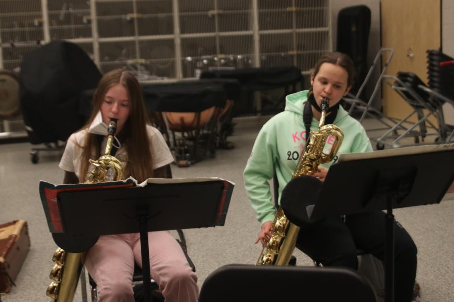 Holding their saxophones, sophomore Michelle Marney and junior Cassie Frias practice a section of a song.