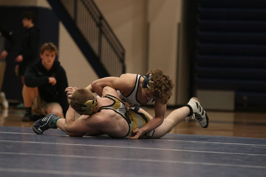 Trying to flip his opponent over, sophomore Brady Mason adjusts his body over him and begins to turn his back to touch the mat. 