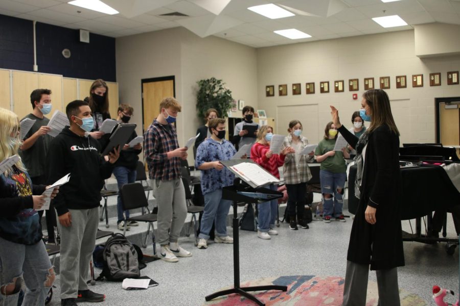 With her hand up, choir teacher Jessie Reimer leads the Jag Singers students to sing as they practice a song.