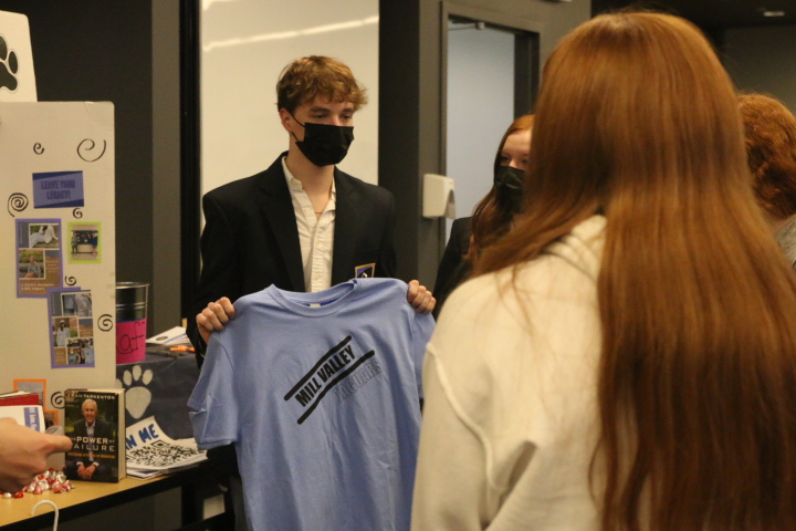 Senior Carson Howe shows a shirt from the Catty Shack to the 8th graders. 