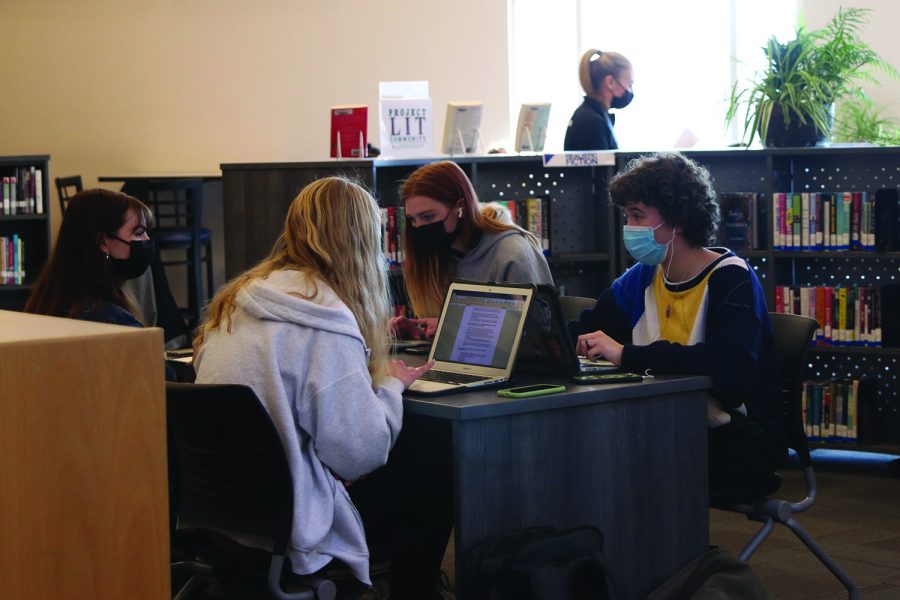 Working on their laptops, sophomores Sarah Anderson, Brittany Knickerbocker, Audrey Holick and Madeline Olivier sit at the new tables Friday, Jan. 21. Many of the new tables and books have not been set up yet, either because of lack of space or shelving.