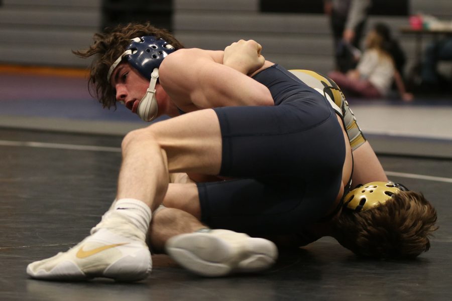 Working to pin his opponent, sophomore Maddox Casella holds him down.