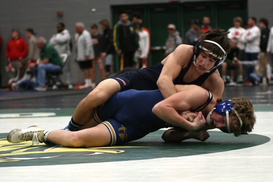 Taking down his opponent, junior Eddie Hughart wrestles in the annual Bobcat Classic hosted by Basehor-Linwood High School Friday, Jan. 14.