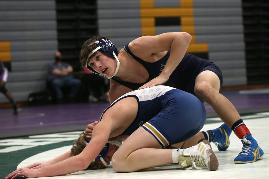 After winning a point, junior Eddie Hughart presses down on his opponent to stand up.