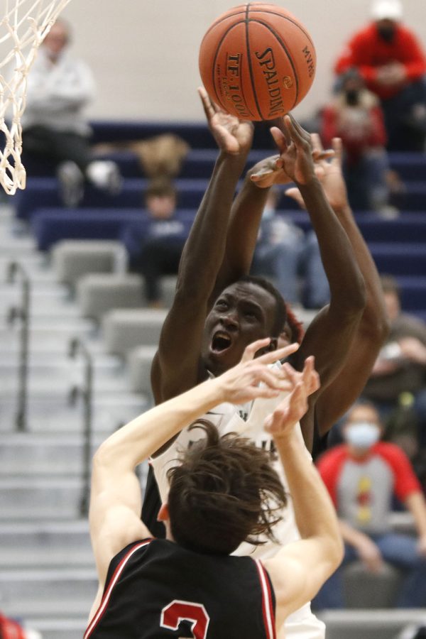 Junior Nen Matlock jumps through two defenders to get the ball in the hoop. He ended the game with 11 points, but the team had an unfortunate loss of 51-69