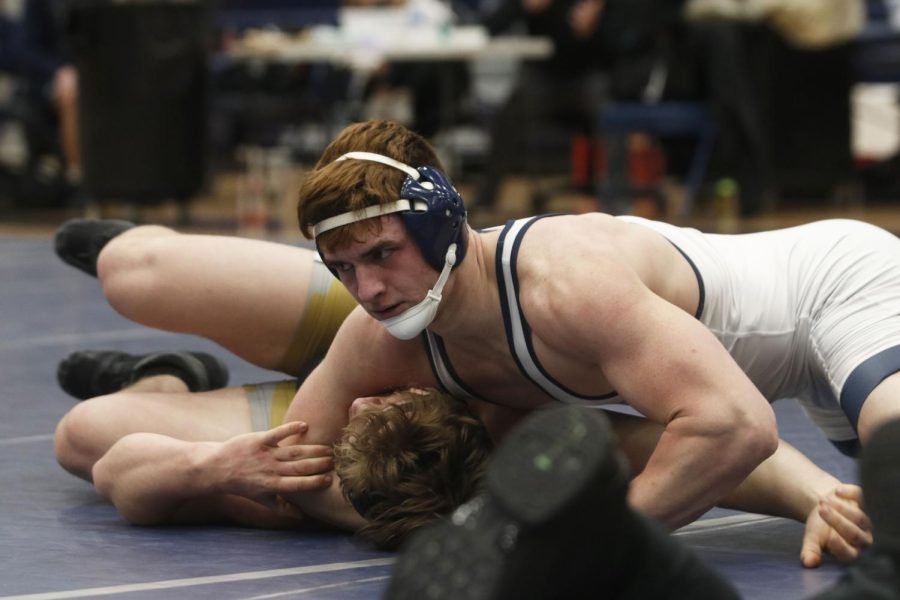 Putting his opponent in a headlock, senior Payton Douglas pins him to the ground.