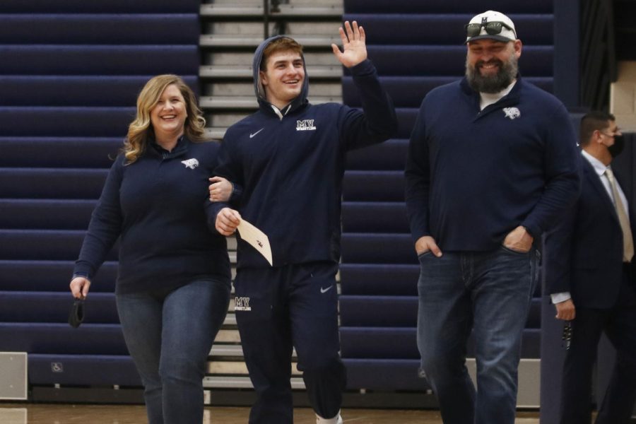 Hand in the air, senior Payton Douglas waves to the crowd as he gets recognized for senior night.