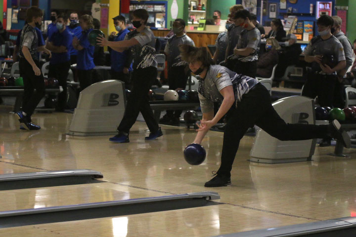 As he throws the ball, senior Laird Toland aims at the pins. 

