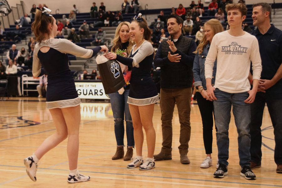 Smiling at junior Kate Kline, senior Addisen Chezem accepts her a gift from the rest of the cheer team. 