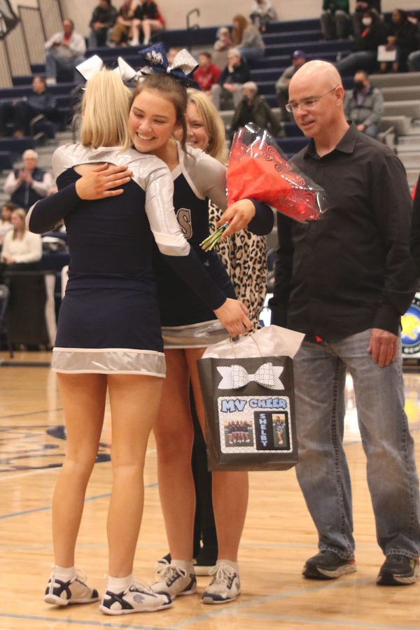 Accompanied by her parents, senior Shelby Easum smiles as she accepts her senior gift. 