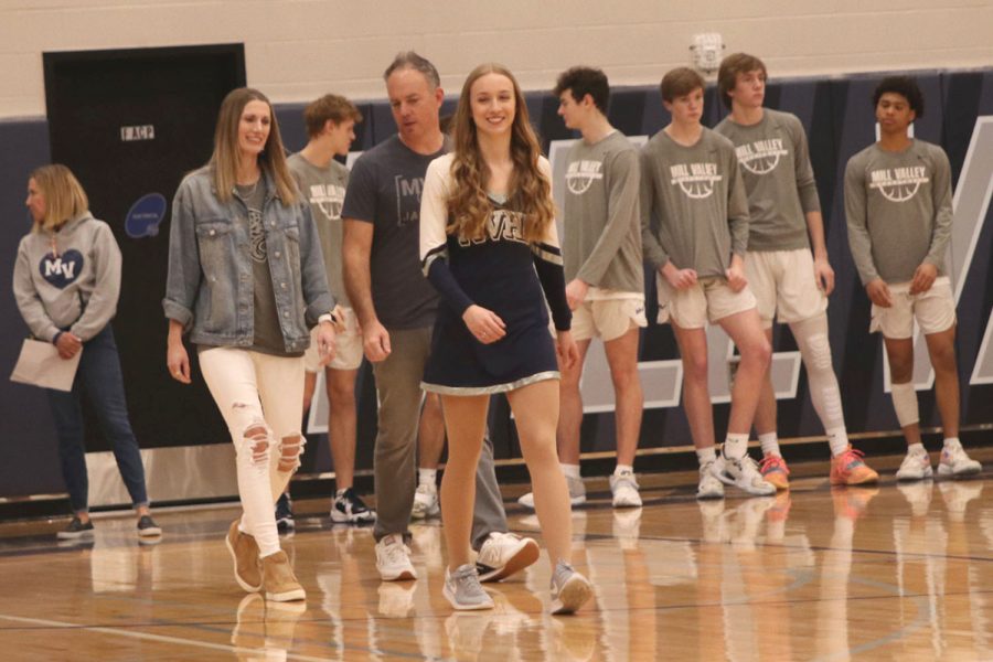 Followed by her parents, senior Hadley Skinner smiles to her friends in the stands.