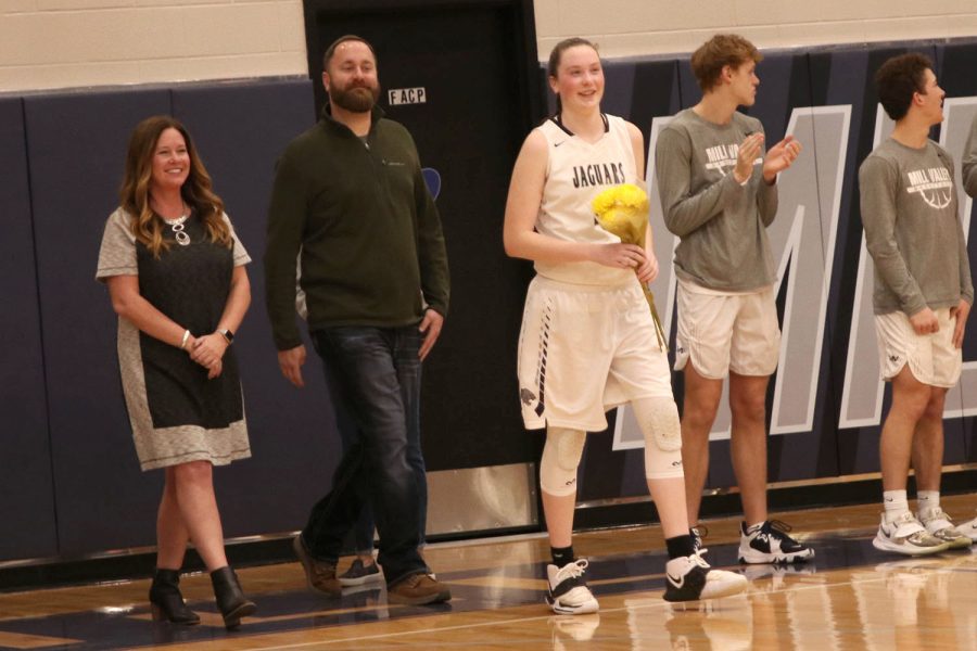 Flowers in hand, senior Maddie Vosburg walks onto the court followed by her parents.
