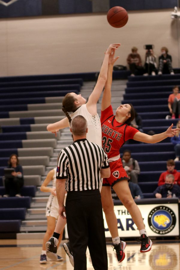 To start the game, senior Maddie Vosburg reaches above her opponent for the jump ball. 