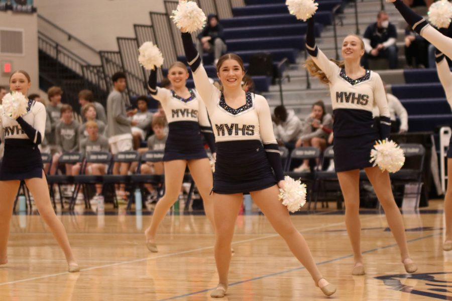 Smiling as the silver stars walk onto the court, senior Anna Brazil waves to the crowd. 