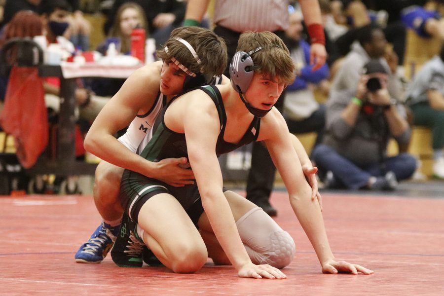 On top of the opponent, junior Eddie Hughart places his hands in the ready position so he can attack at the whistle. 