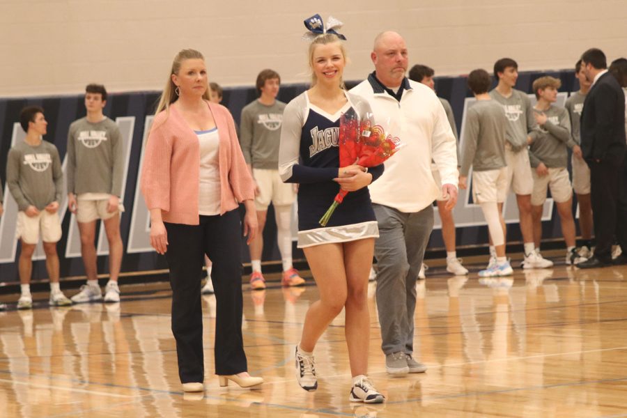 Holding flowers from her parents, senior Audra Finely smiles to her friends in the stands.