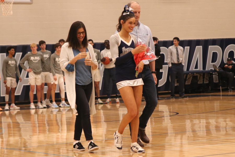 Alongside her parents, senior Olivia Lecuru smiles as she walks out.