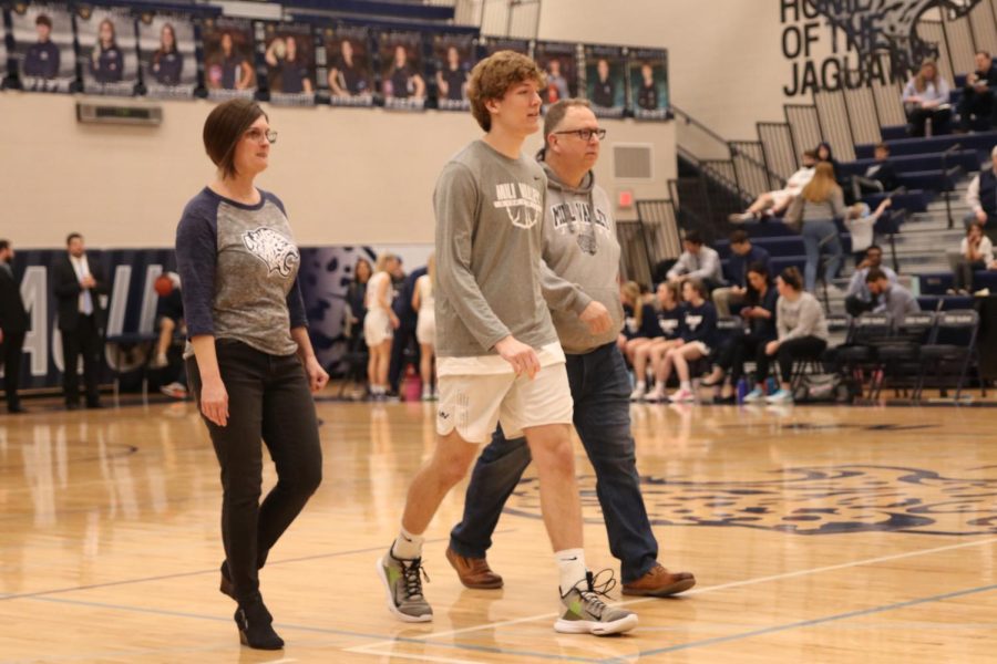 Beside both his parents, senior Zach Shrader looks to his teammates and friends in the crowd. 
