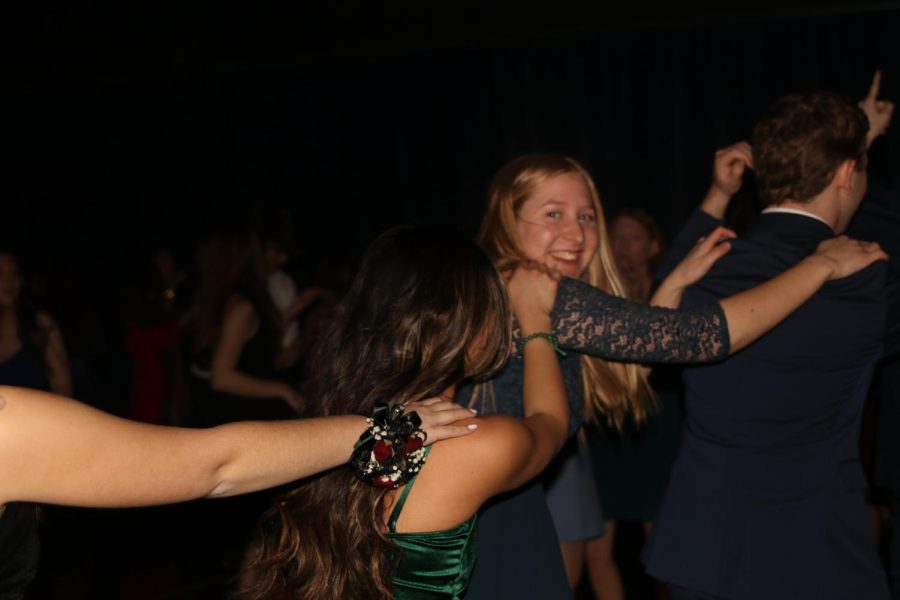 Holding on to senior Jordan Mannings back, senior Summer Anderson smiles as she and others form a conga line at the dance. 