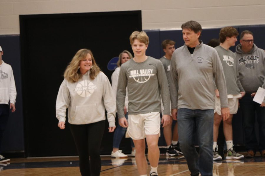 Alongside his parents, senior Ben Fitterer walks across the court to be recognized. 