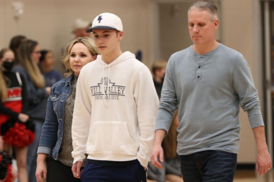 In between his parents, senior Brendan Akehurst is recognized as a boys swim and dive senior.