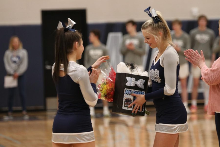 Senior Audra Finley accepts her senior gift from junior Eden Hakes on senior night.