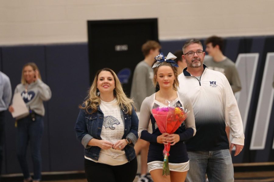 Between her parents, senior Rheagan Handy is recognized as a cheer senior.