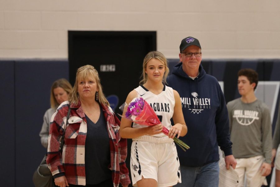 Senior Maggie Smith walks across the court as she is recognized on senior night.