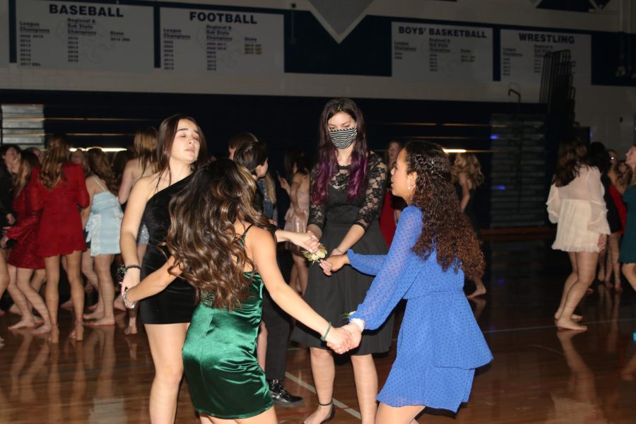 Spinning in a circle, juniors Patricia Solis Botella, Gabby Delpleash, Avery Gathright, and senior Jada Eggleston dance to a song at Winter Homecoming. 