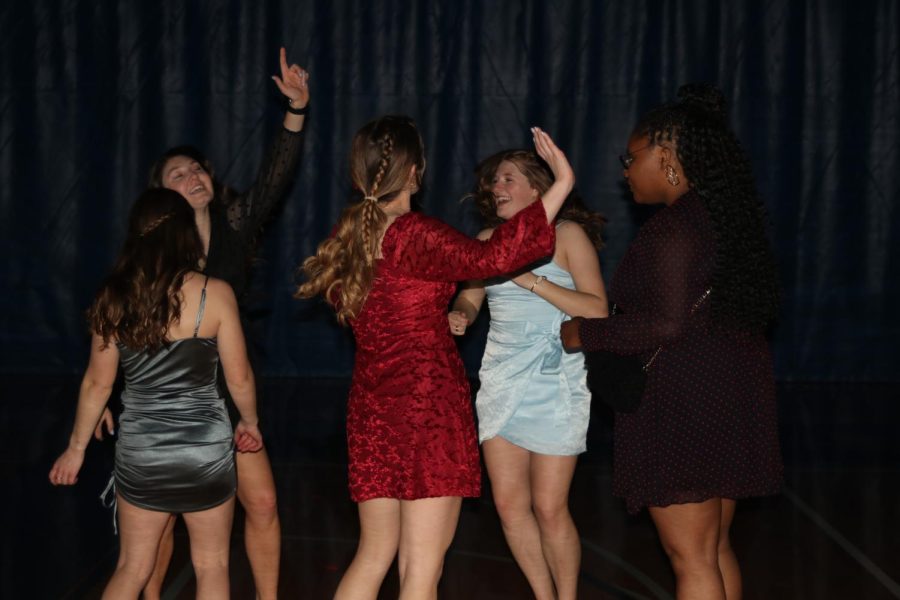 Facing each other, sophomores Kynley Verdict, Ellie Walker, Kate Pfeister, Lucy Roy and senior Hannah Hunter laugh while dancing.