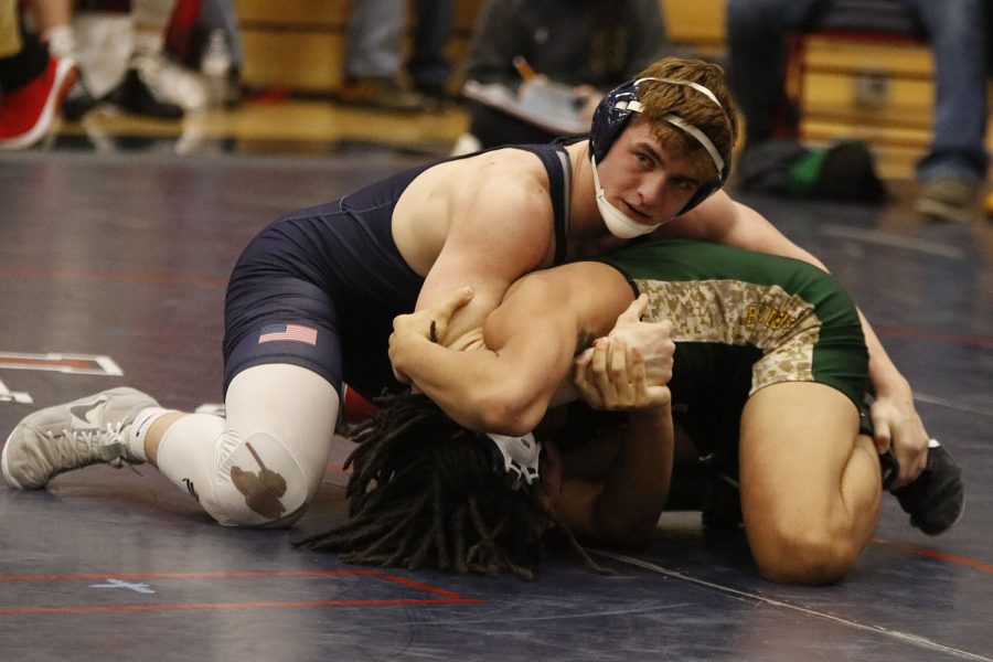 Looking towards his coaches, senior Payton Douglas holds his opponent in his arms to prepare to make his next move. 